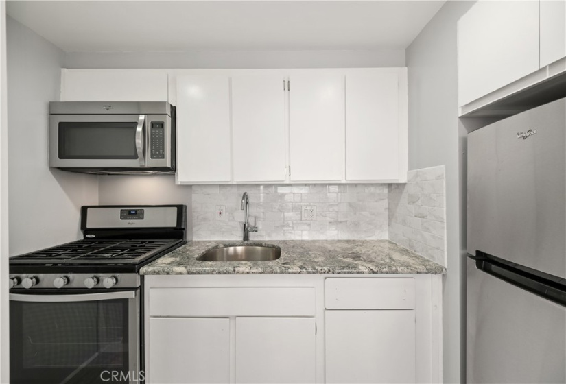 Kitchen with stainless steel appliances and granite counter.